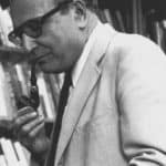 A picture of Seymour Martin Lipset smoking a pipe in front of a bookshelf