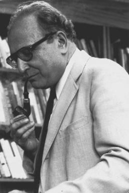 A picture of Seymour Martin Lipset smoking a pipe in front of a bookshelf